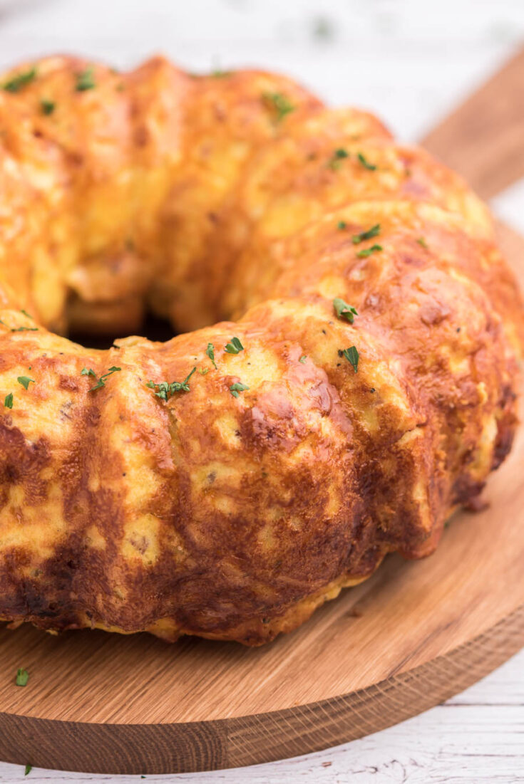 angled down shot of egg breakfast casserole that was shaped by a bundt pan. served on wooden tray with handle.