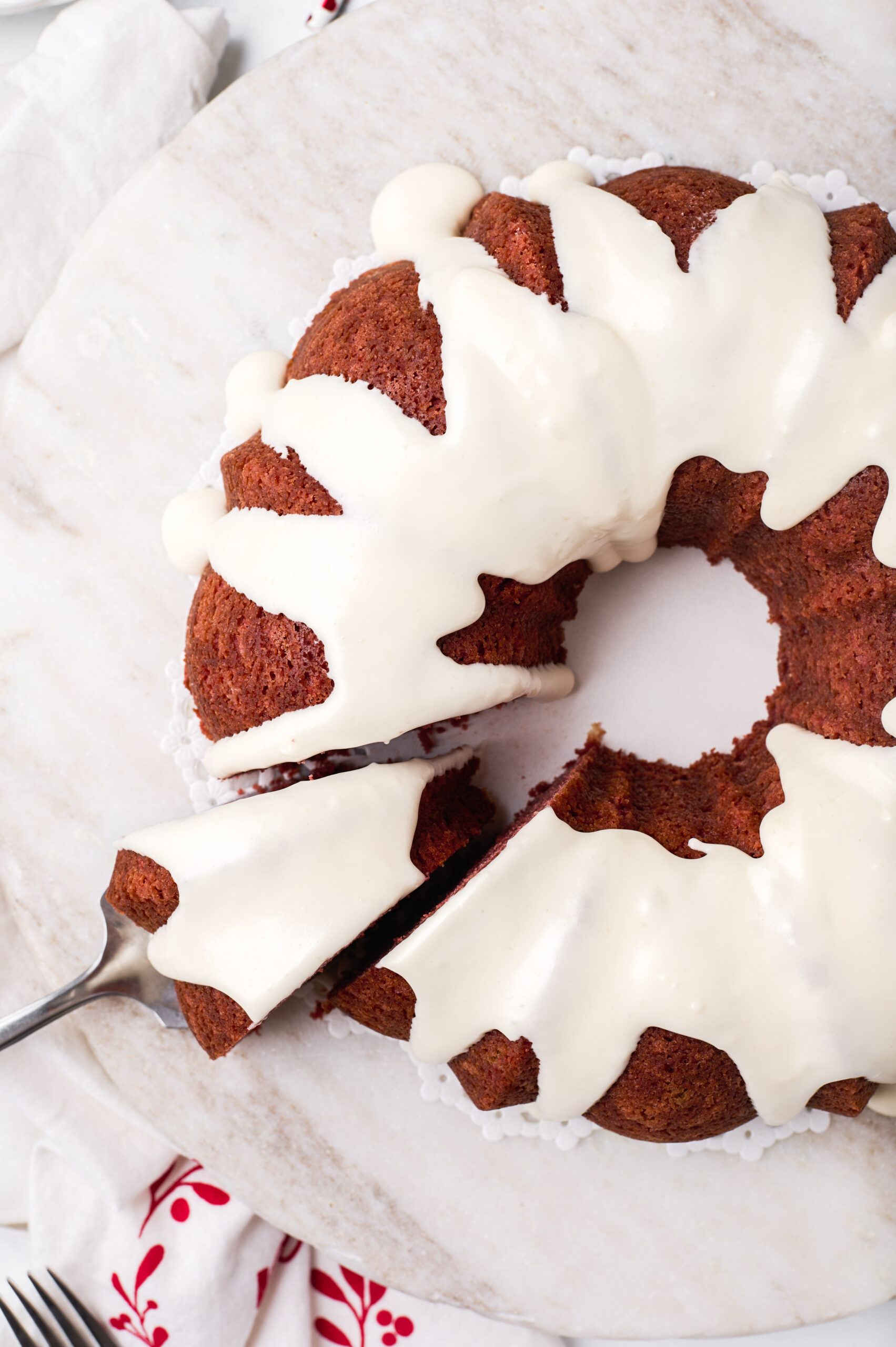 birds eye image of a whole red velvet bundt cake with a slice being removed