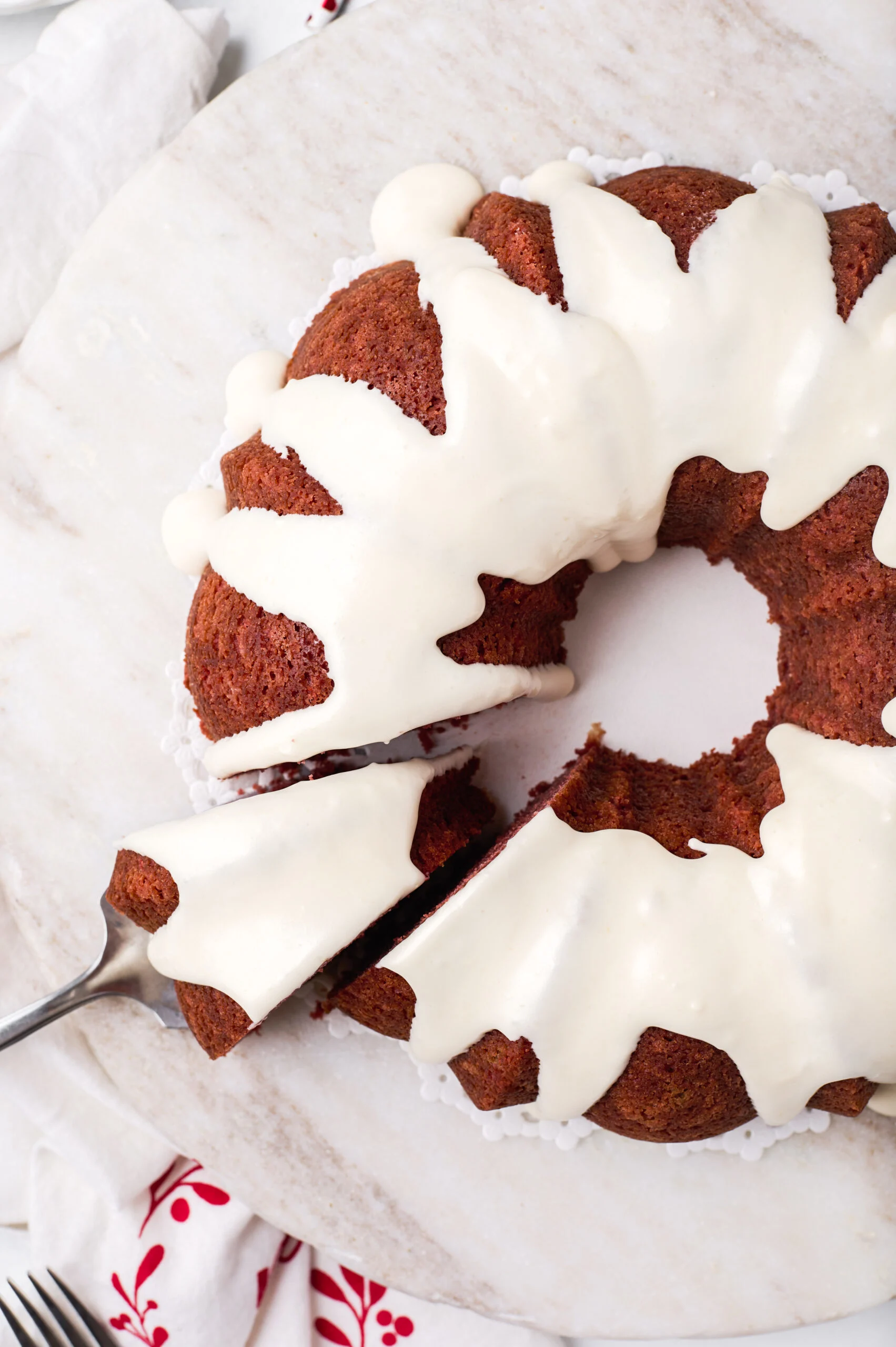 birds eye image of a whole red velvet bundt cake with a slice being removed