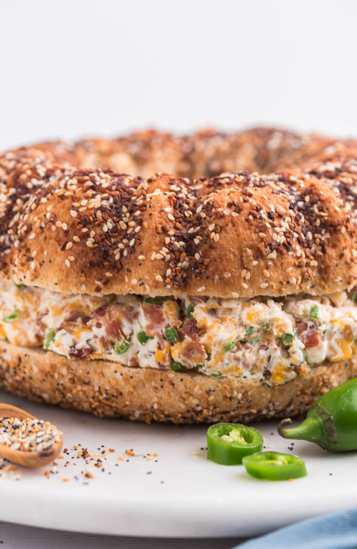 close up image of jumbo everything bagel filled with cream cheese