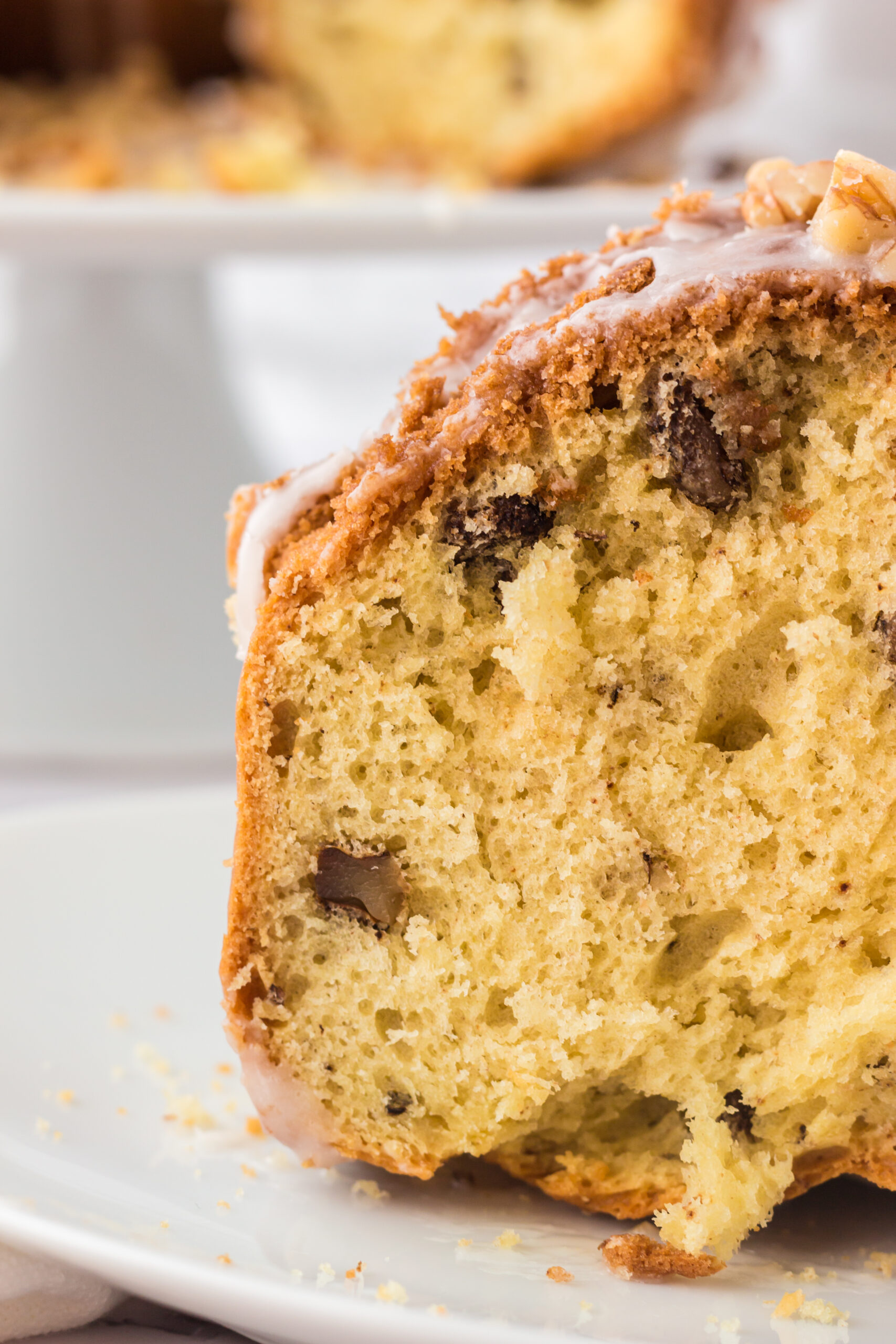 close up of the inside of a slice of maple walnut bundt cake on a white plate