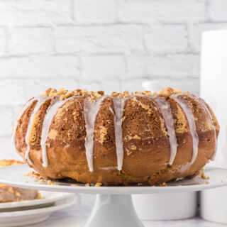 vertical image of a whole maple bundt cake on a white cake stand