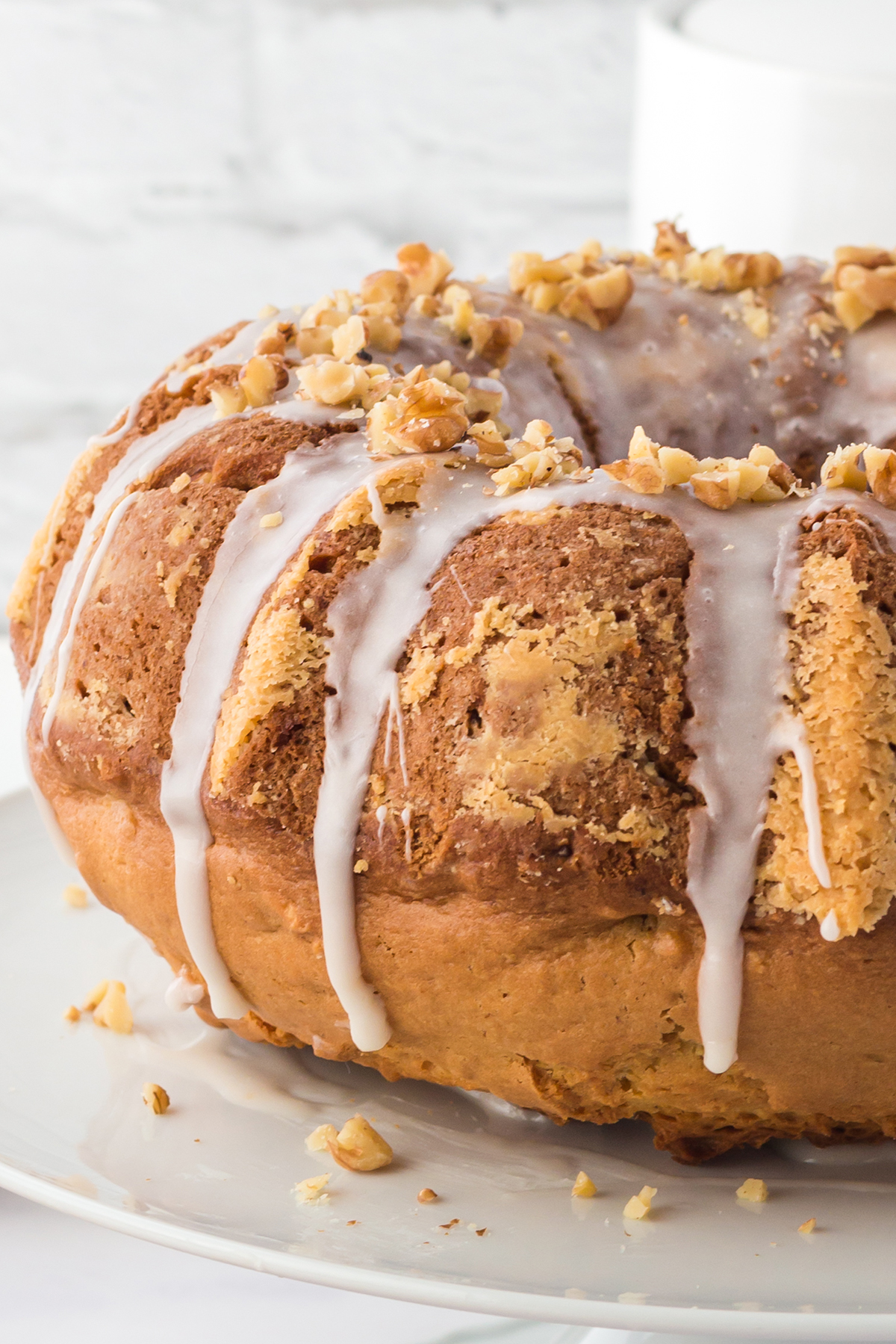 close up image of maple walnut bundt cake on a white plate