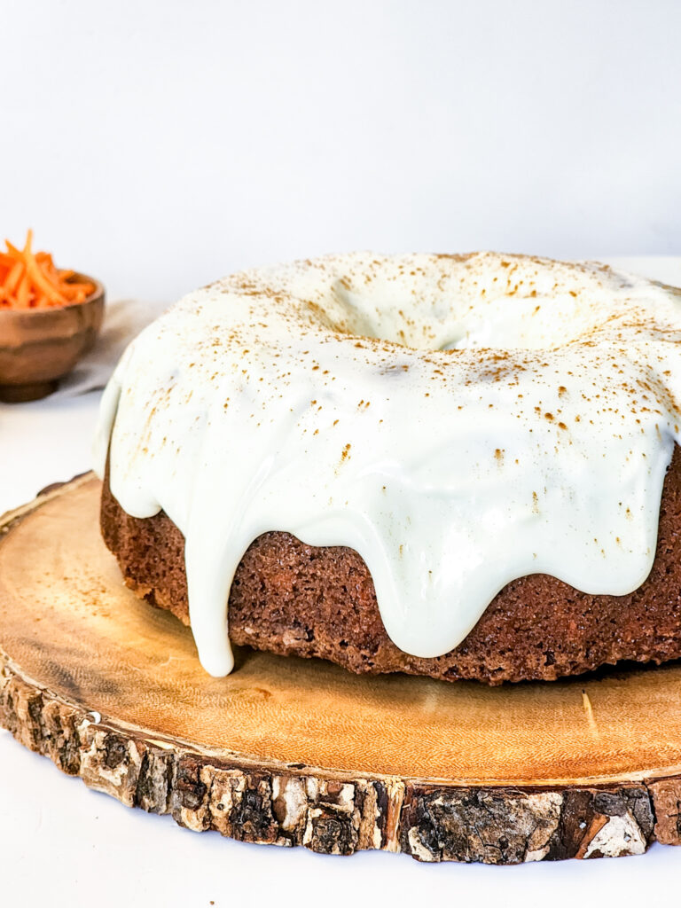 cream cheese carrot bundt cake on a wooden plate